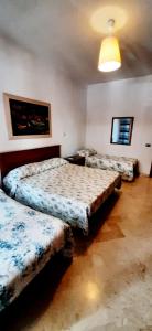1 dormitorio con 3 camas y luz en Casa Piacquadio en Bari