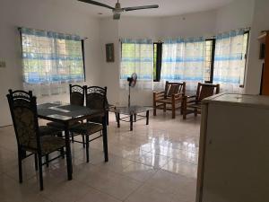 una sala da pranzo con tavolo, sedie e finestre di Villa Juana a Panglao