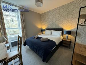 a bedroom with a bed with a blue blanket at Cross Wynd Apartment in Hawick