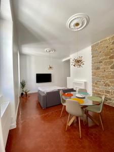 a living room with a table and a bed at Grands T2 Cours Napoleon in Ajaccio