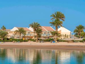 a resort on the beach with palm trees and water at Movenpick Resort & Spa El Gouna in Hurghada