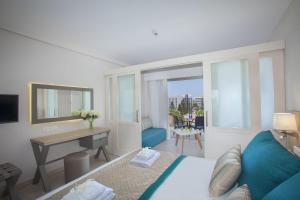 a hotel room with a bed and a desk and a desk at Atlantica Aeneas Resort in Ayia Napa