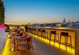 a bar on the roof of a building with chairs and tables at art'otel Zagreb, Powered by Radisson Hotels in Zagreb