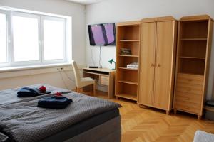 a bedroom with a bed and a desk and a television at Apartmanový dom Stummerova in Topoľčany