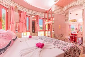 a bedroom with a large bed with pink bows at Paco's Resort Barbie House in Oziás