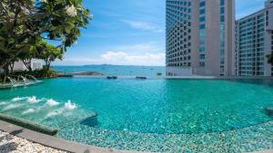 een zwembad met blauw water en hoge gebouwen bij Holiday Inn Pattaya, an IHG Hotel in Pattaya