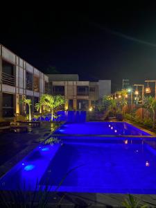 - une piscine avec éclairage bleu la nuit dans l'établissement Apto 001 B GAMBOA, à Porto de Pedras