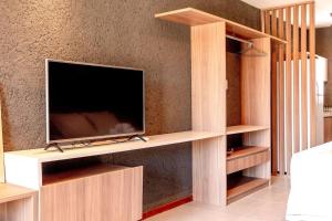 un salon avec une télévision sur un mur dans l'établissement Apto 001 B GAMBOA, à Porto de Pedras