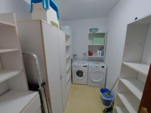 a laundry room with a washing machine and a washer at INcostadamorte Vivienda Martinez in Cee