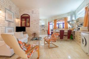 a living room with a couch and chairs and a kitchen at Paco's Superior Double Villa 15 in Oziás