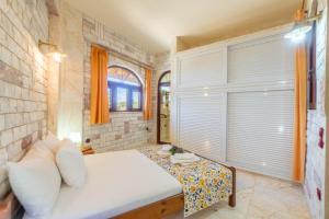 a bedroom with a bed and a brick wall at Paco's Superior Double Villa 15 in Oziás +13 photos