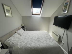 a small bedroom with a bed and a television at 21 Victoria, Kilkee in Kilkee +4 photos