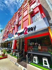 a store with two stools in front of a building at Good2Stay Budget Hotel in Malacca