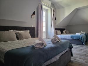 a bedroom with two beds with towels on them at Leao de Ouro in Matosinhos