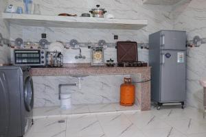 APPARTEMENT DE LUXE A LAAYOUNe في العيون: مطبخ مع موقد وثلاجة