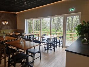 um restaurante com mesas e cadeiras e uma janela em Sólheimahjáleiga Guesthouse em Solheimahjaleiga