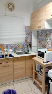 a kitchen with wooden cabinets and a sink at Appartement tout confort in Athens
