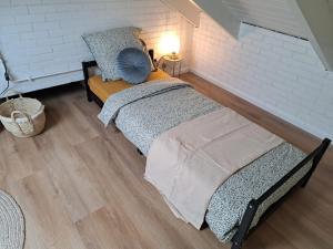 a bedroom with two beds and a white brick wall at Stad & Strand Appartement in Middelburg