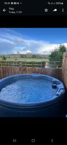 a hot tub with blue water in front of a fence at Crabmill Glamping with hot tub in Bewdley