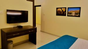 Habitación con cama y TV en la pared. en Bodhi Retreat, en Ajmer