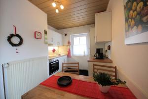una pequeña cocina con mesa y alfombra roja en Jautz RE13, en Sögel