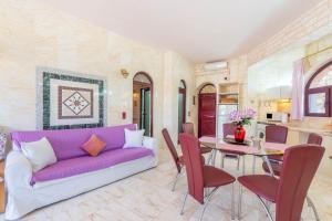 a living room with a purple couch and a table at Paco's Resort Family Villa 12 in Oziás