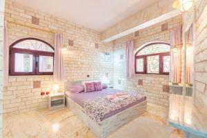 a bedroom with a bed in a brick wall at Paco's Resort Family Villa 12 in Oziás