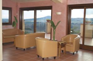 カステルヌオーヴォ・ディ・ポルトにあるFrancalancia Country Resortの椅子とテーブルと植物のある部屋