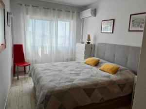 ポルティマンにあるPanorama Family Apartmentの黄色い枕が2つ付いたベッドのある寝室