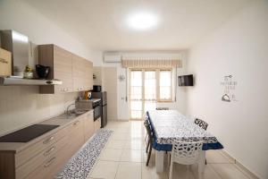 a kitchen with a table and a table and chairs at Mare Fuori casa vacanze in Castellammare di Stabia