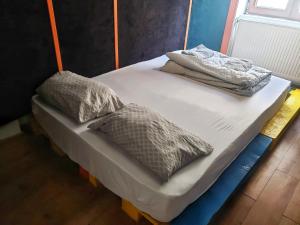 a bed with two pillows on it in a room at Bucuresti Bucuresti Hostel in Bucharest