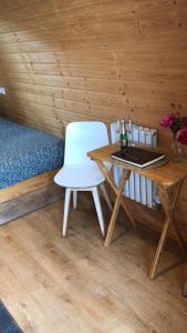 a white chair sitting at a table in a cabin at Crabmill Glamping with hot tub in Bewdley