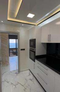 een keuken met witte kasten en een magnetron bij Welcome to THE VIEW! in Al Hoceïma