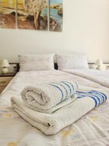 a pile of towels sitting on top of a bed at Maja V Apartmani Sokobanja in Soko Banja
