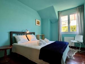 a blue bedroom with a bed with towels on it at Casa Mirador del Pas - Monabri in Boó de Piélagos +46 photos