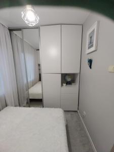 a bedroom with a white bed and a mirror at Apartament na Sadowej in Sanok