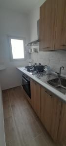 a kitchen with a stove and a sink and a window at Casa Vacanze Altea in Santa Flavia +21 photos