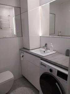 a bathroom with a washing machine and a sink at Apartament na Sadowej in Sanok +19 photos