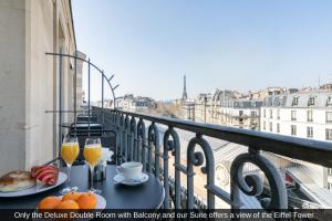 Un balcón con una mesa con vasos de zumo de naranja. en Sublim by Sweet Inn en París