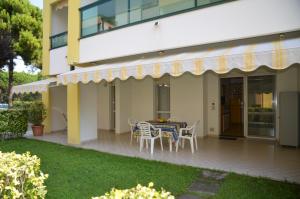a patio with a table and chairs outside of a building at Residenza Le Altane in Bibione