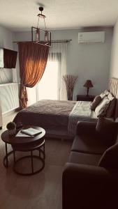 - une chambre avec un lit, une table et un canapé dans l'établissement Nina Apartment, à Dráma