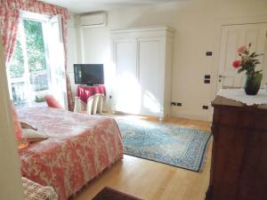 Un dormitorio con una cama y un televisor en una habitación. en Villa Olivia, en Bérgamo