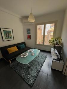 a living room with a glass table and a couch at Perfectly located holiday place in Beaulieu-sur-Mer