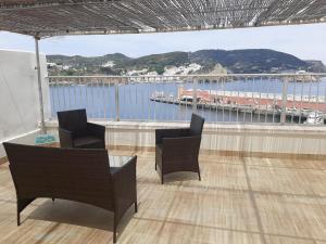 a balcony with chairs and a table and a view of the water at VisitPonza - Le Naiadi in Ponza +14 photos