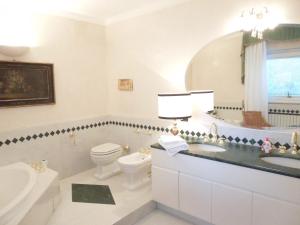 Un baño con inodoro, lavabo y espejo. en Villa Olivia, en Bérgamo 23 fotos más