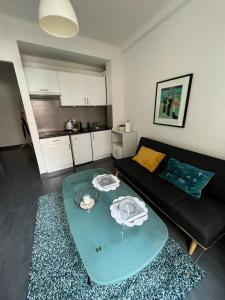 a living room with a black couch and a glass table at Perfectly located holiday place in Beaulieu-sur-Mer