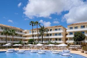 una piscina con sombrillas y sillas y un edificio en FERGUS Club Mallorca Waterpark, en Magaluf