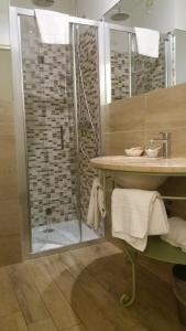 y baño con ducha y lavamanos. en Hotel Borgo Antico en Como