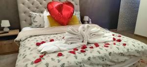 a bed with white towels and red roses on it at President 034 in Arandjelovac