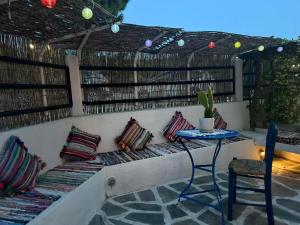 a patio with a bench with pillows and a table at Hara's House 2 in Gerakini +38 photos